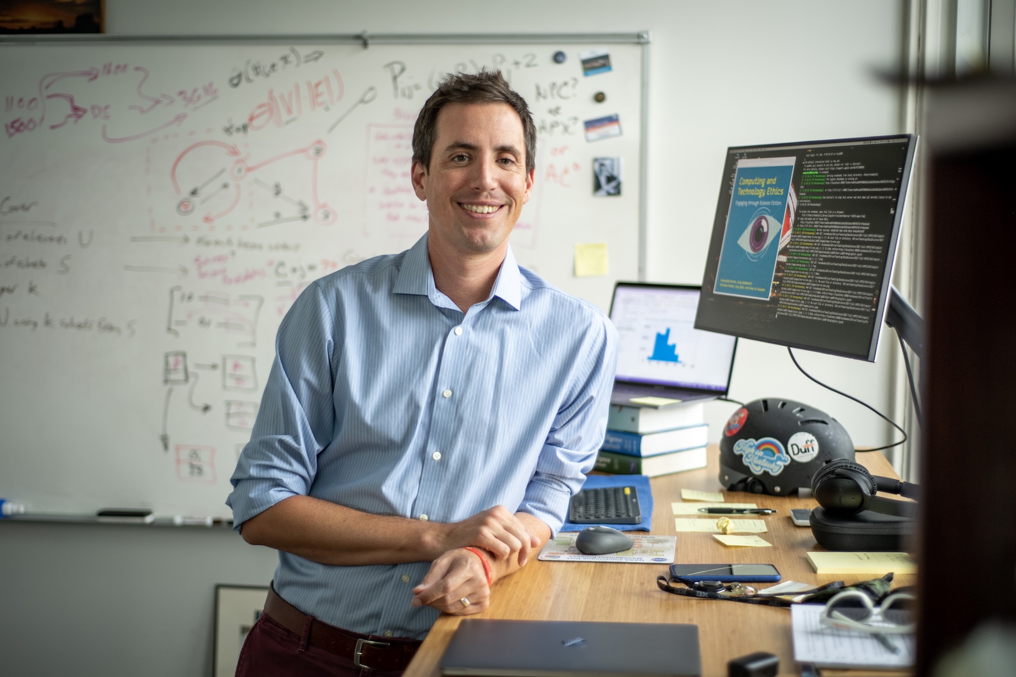 Nick Mattei in a room with a whiteboard behind him.