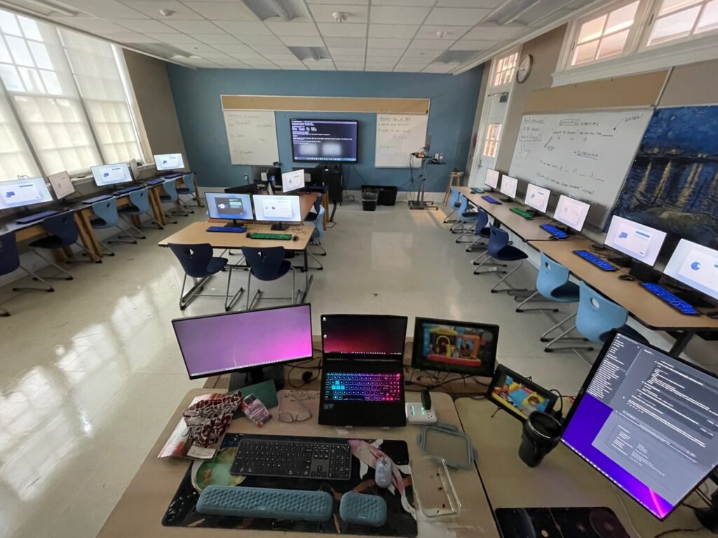 Classroom full of computers and glowing keyboards.