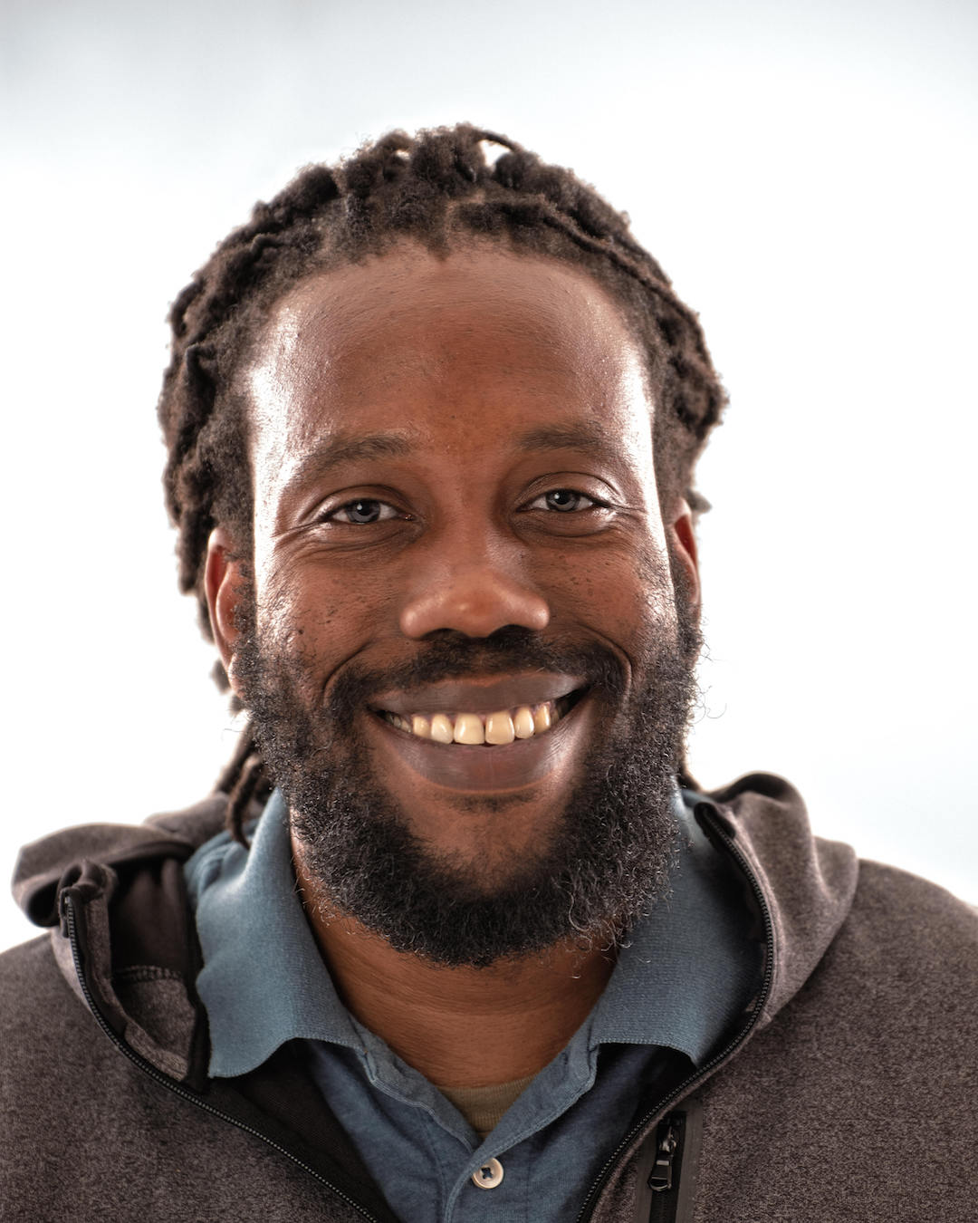 A headshot photo of Johnnie James II smiling.